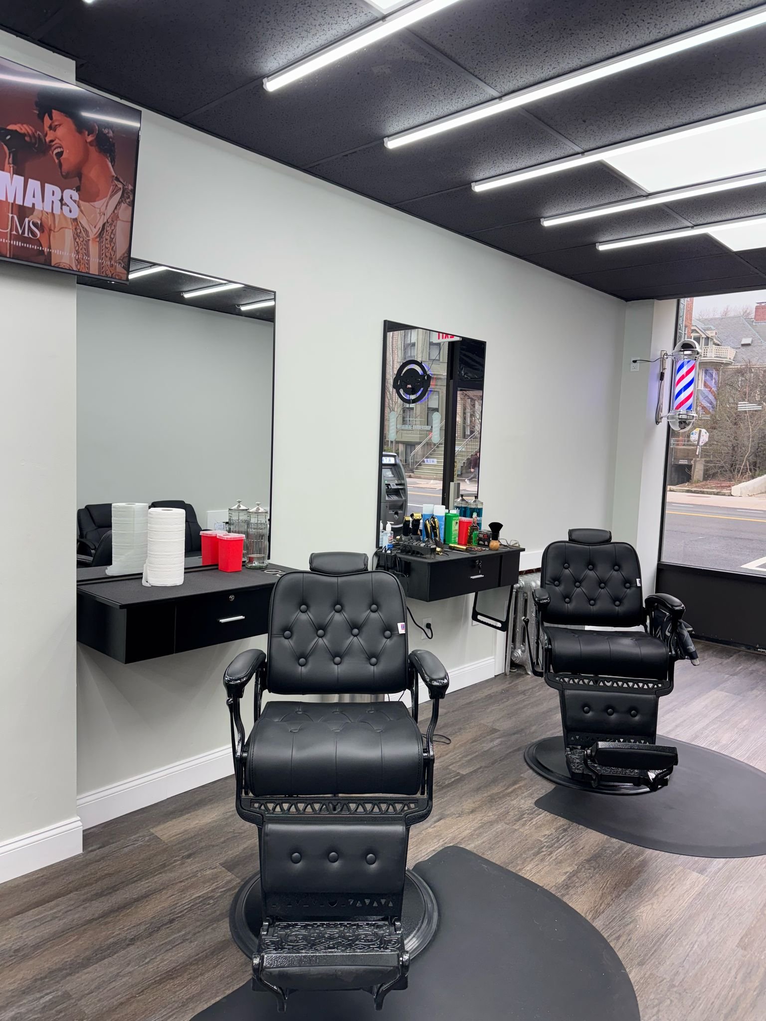 Interior of Belvedere Barbershop — black tufted chairs, modern space